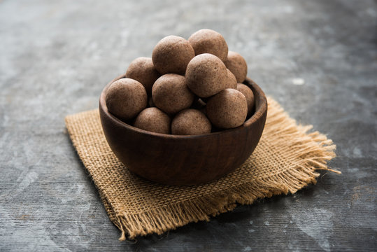 Nachni laddu or Ragi laddoo or balls made using  finger millet, sugar and ghee. It's a healthy food from India. Served in a bowl or plate over moody background. Selective focus