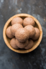 Nachni laddu or Ragi laddoo or balls made using  finger millet, sugar and ghee. It's a healthy food from India. Served in a bowl or plate over moody background. Selective focus