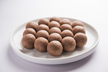 Nachni laddu or Ragi laddoo or balls made using  finger millet, sugar and ghee. It's a healthy food from India. Served in a bowl or plate over moody background. Selective focus