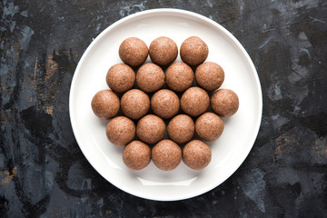 Nachni laddu or Ragi laddoo or balls made using  finger millet, sugar and ghee. It's a healthy food from India. Served in a bowl or plate over moody background. Selective focus
