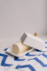 white ceramic butter-dish and towel on white background