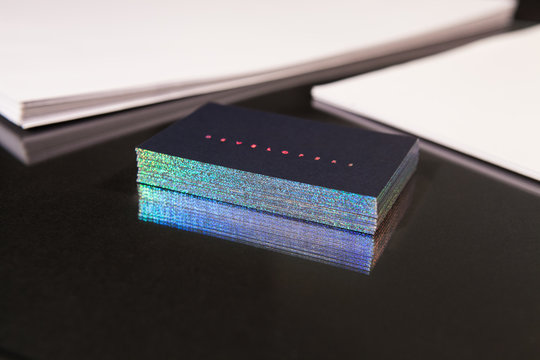 Stack Of Business Cards With A Hologram On A Black Background