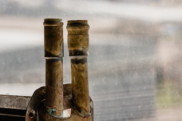 Copper pipes on the background of glass, pointing up.