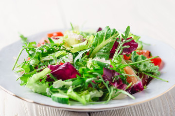 Fresh organic super food salad on white plate with fork on side