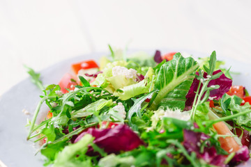 Fresh organic super food salad on white plate with fork on side