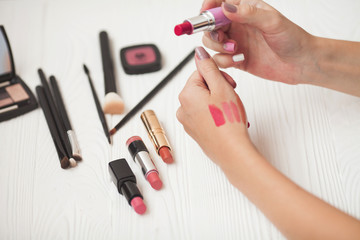 Beautiful lip makeup set. Woman with pomade. Make up artist shows lipstick