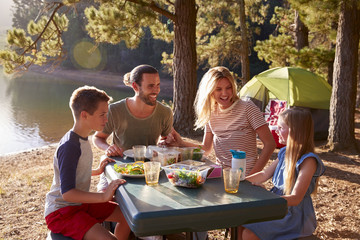 Family Camping By Lake On Hiking Adventure In Forest