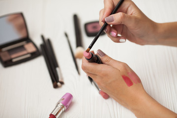 Tube of lipstick with a brush make-up on white background. Make up set, soft makeup brushes and maskara