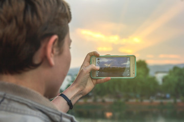 Tourist taking picture of beautiful sunset