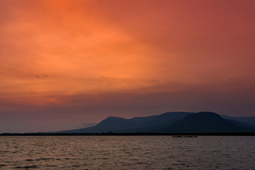 Sunset in Kampot sea coast with mountains in the background