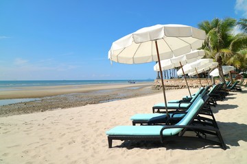 Bed beach and white umbrella on tropical beach with coconut tree in the summer morning. Nature and travel concept.