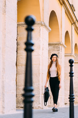 girl with long hair dressed like a french woman walking near a b