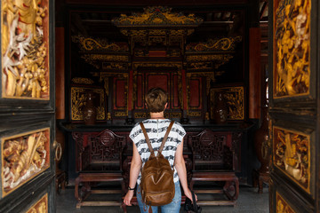 Obraz premium Woman tourist enters traditional Chinese, wooden, house