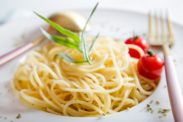 Spaghetti pasta with cherry tomatoes on white plate