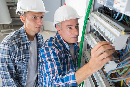 electrician engineer workers in front of fuse switch board
