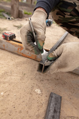 A man makes metal doors in a factory