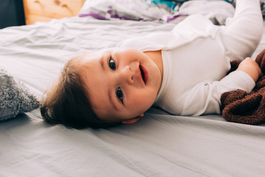 Funny baby lying on bed