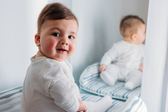 Portrait of smiling baby boy sitting on mat