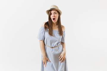 Young tender elegant woman in blue dress, hat keeping mouth wide open, looking surprised, posing isolated on white background. People, sincere emotions, lifestyle concept. Advertising area. Copy space