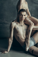 The young modern ballet dancers posing on gray studio background