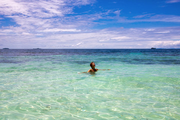 woman enjoy her bath in the beautiful water of exotic island, raja ampat archipelago