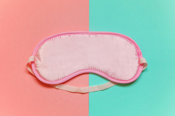 Sleeping eye mask, isolated on pink and blue pastel colourful trendy geometric background. Do not disturb me, let me sleep. Rest, good night, insomnia, relaxation, tired, travel concept