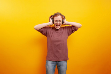 young woman screaming and listen music at headphones