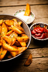 Baked potato fries on wooden table