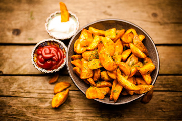Baked potato fries on wooden table
