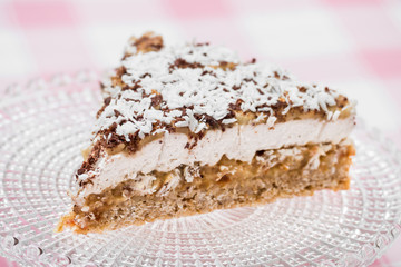 Vegan banoffee pie made from oats, dates, coconut cream and bananas on glass cake stand, high angle view