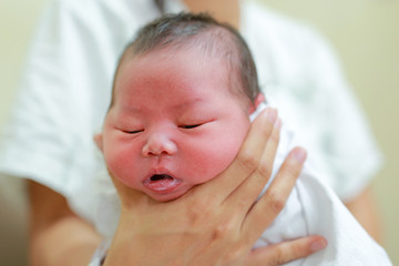 Mother is belching for infant baby.
