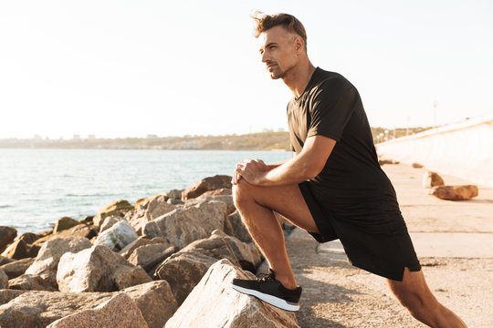 Portrait of a handsome sportsman doing stretching exercises - Powered by Adobe