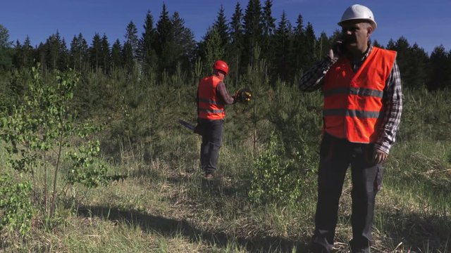 Lumberjack talking on smartphone in forest