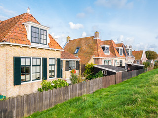 Fototapeta na wymiar Back of old cottages alongside dike in historic town of Makkum, Friesland, Netherlands