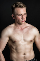 Fototapeta premium Young sexy guy and black background.