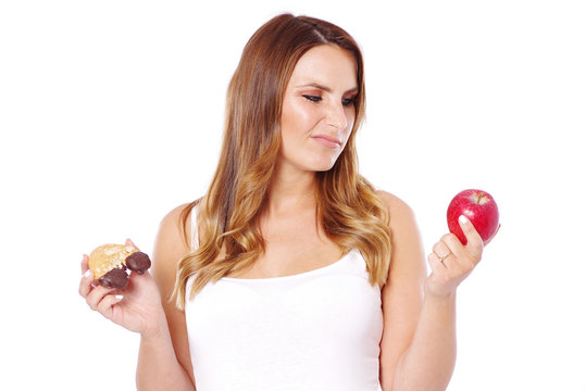 Frau mit gesundem und ungesundem Essen, Apfel oder süßes Gebäck  