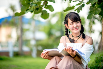 Asian women reading a book under the tree,select focus.