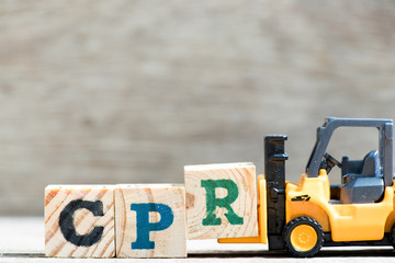 Toy forklift hold letter block R in word CPR (abbreviation of Cardiopulmonary resuscitation) on...