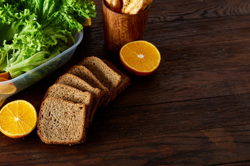 Continental breakfast with fresh pastry, fruits, greenery and beverages over rustic wooden background, top view,