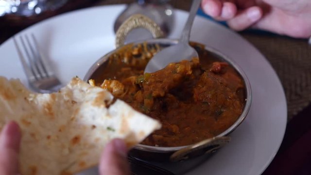 A delicious Indian dish is served in a national plate, with a delicious flat cake in a tandoor, close-up. slow motion, 1920x1080, full hd