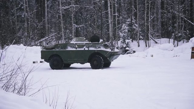 Armoured personnel carrier in a winter scenery. Clip. Military armored personnel carrier in forest