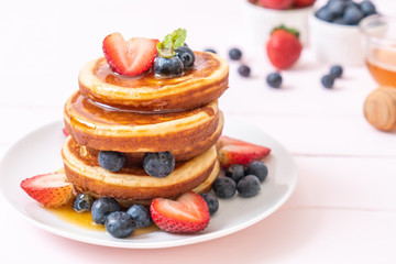 pancake with fresh blueberries, fresh strawberries and honey