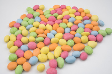 Small colorful chocolate candies on a white background