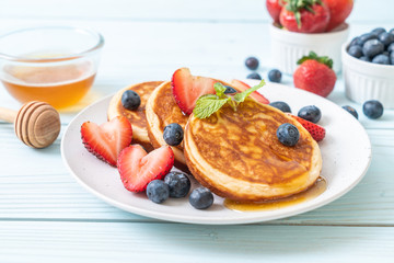 pancake with fresh blueberries, fresh strawberries and honey