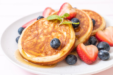 pancake with fresh blueberries, fresh strawberries and honey