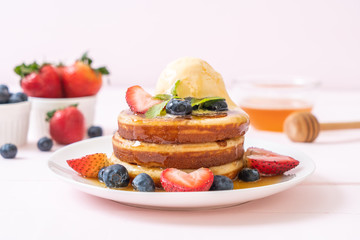 pancake with blueberries, strawberries, honey and vanilla ice-cream