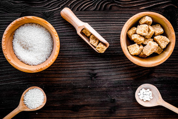 lumps of sugar in bowls on wooden table background top view spac