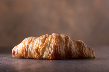 Fresh and tasty croissant  on old copper background.