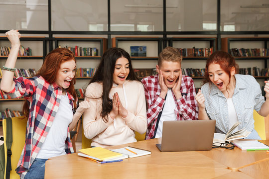 Group of happy teenagers doing homework