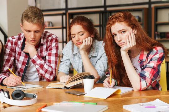 Group of tired teenagers doing homework